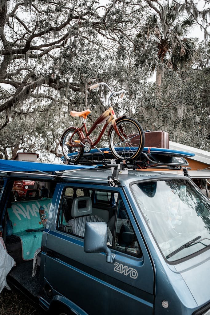 Photo by Connor McManus Bicycle and Surfboard on Top of a Van