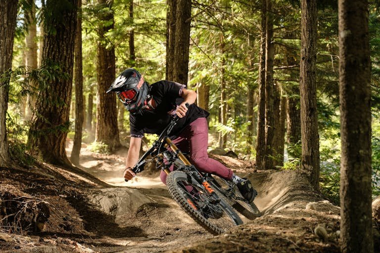 Experience the thrill of mountain biking through a lush forest with speed and precision.