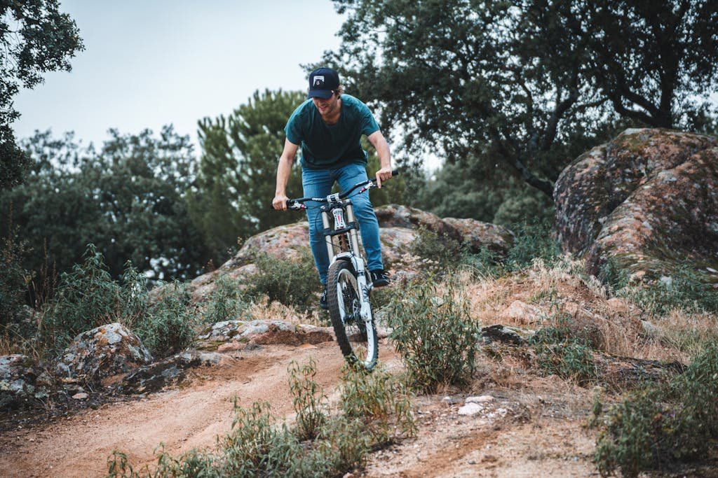 Photo by Gonzalo Mendiola Man enjoying a thrilling mountain bike ride on a rugged trail in the outdoors.
