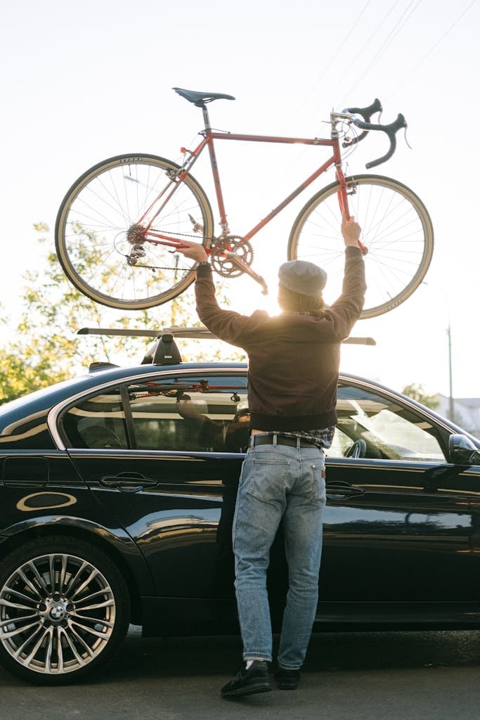 Photo by Ivan Samkov Person Putting the Bicycle on the Car Roof