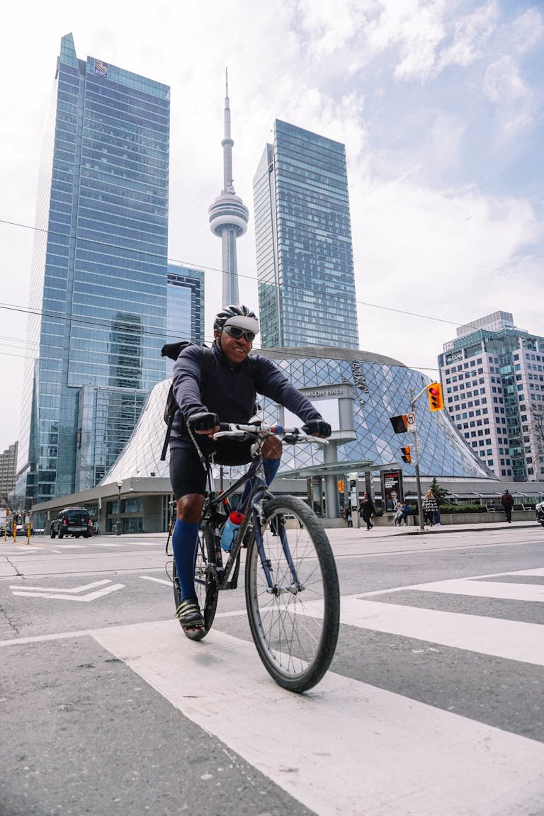 Smiling professional cyclist riding in megapolis