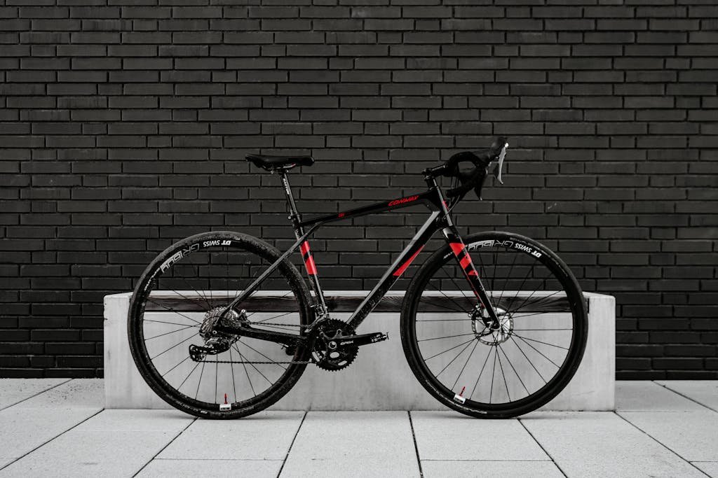 Photo by Bayram Er Black and Red Road Bike Leaning on Concrete Ledge