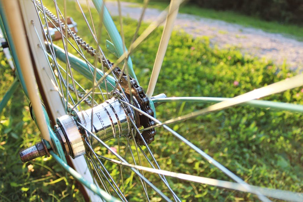 Detailed close-up of a bicycle wheel hub and spokes shimmering in sunlight.