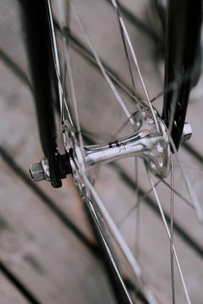 Photo by cottonbro studio High-quality close-up of a bicycle wheel and spokes showcasing chrome and metallic details.