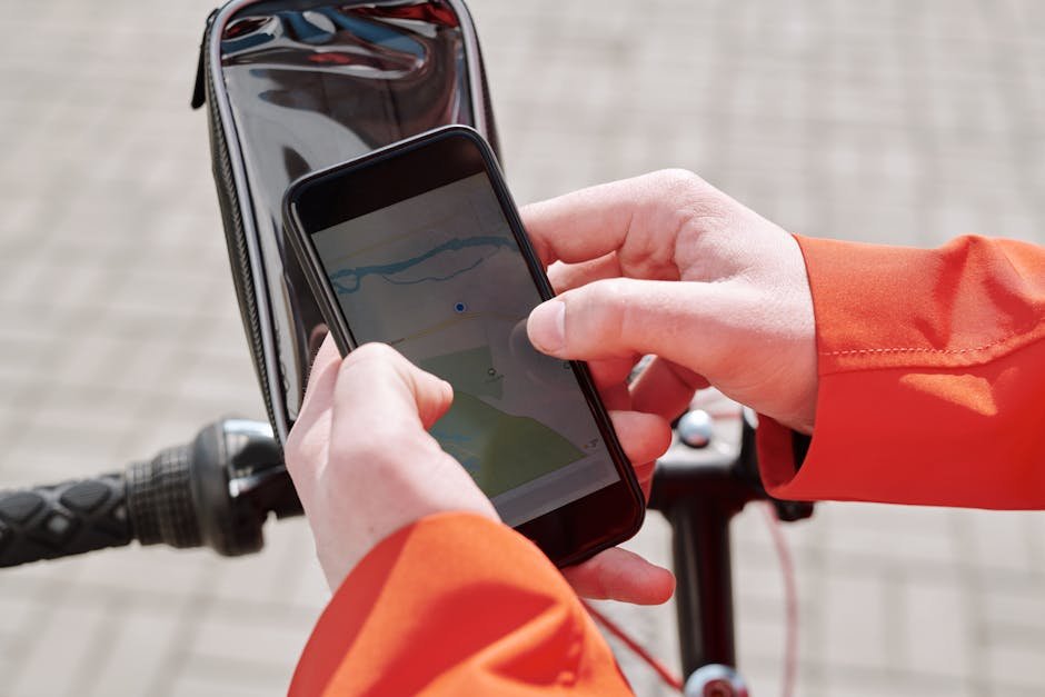 pexels-photo-4392032-4392032 Close-up of cyclist using a smartphone GPS navigation app on a bike mount outdoors.