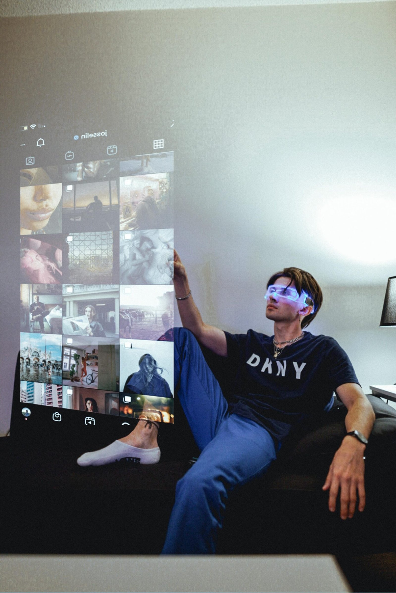 Man wearing futuristic glasses interacting with holographic Instagram interface in modern setting.