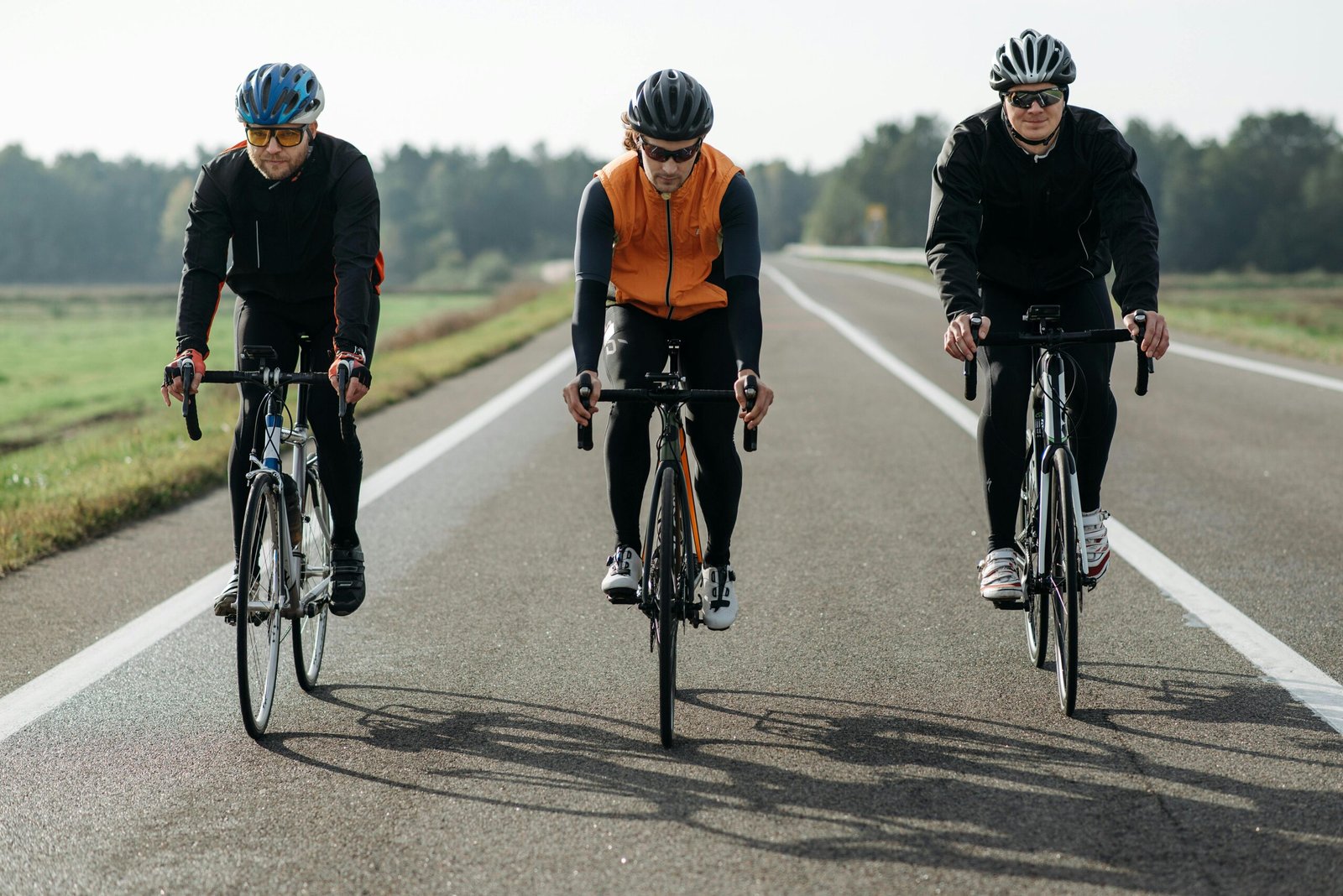 Three cyclists riding bikes outdoors, enjoying recreational activity.